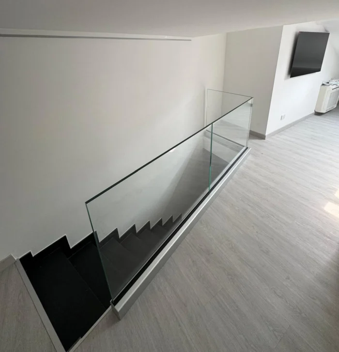 Parapetto interno in vetro 8+8 temperato stratificato installato da Milano Vetri con profilo sopra pavimento in un'abitazione a Milano.