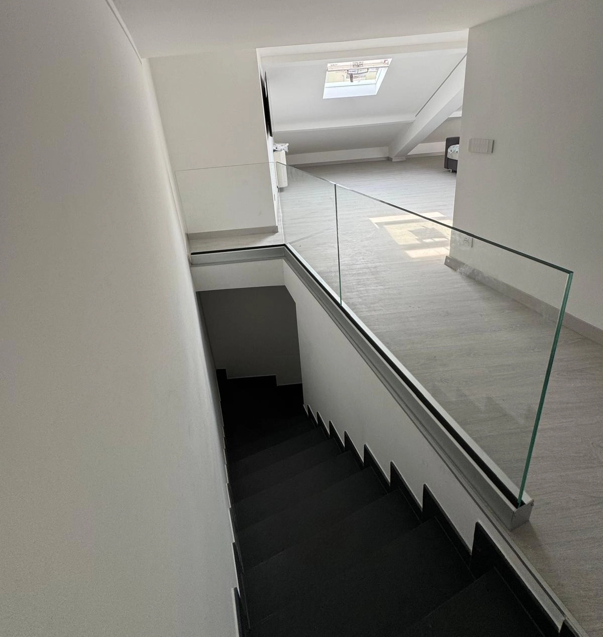 Parapetto interno in vetro temperato stratificato installato da Milano Vetri con profilo sopra pavimento in un'abitazione a Milano. Parapetto interno in vetro temperato stratificato installato da Milano Vetri con profilo sopra pavimento in un'abitazione a Milano.